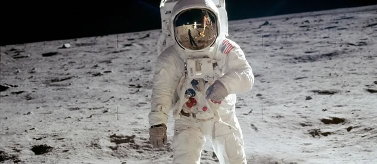An astronaut in a spacesuit plants a flag on a dusty, crater-filled ground. Which iconic milestone is this?