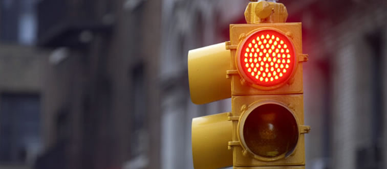 Blink and think — what action must you take at a flashing red traffic light?