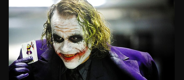 Blink and think — in which cinematic masterpiece does Heath Ledger don the purple suit, green hair, and scarred grin?