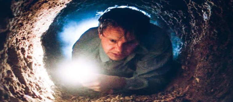 Blink and think — which cinematic hero spends decades scraping walls with a rock hammer only to escape through an absolute nightmare of a plumbing system?